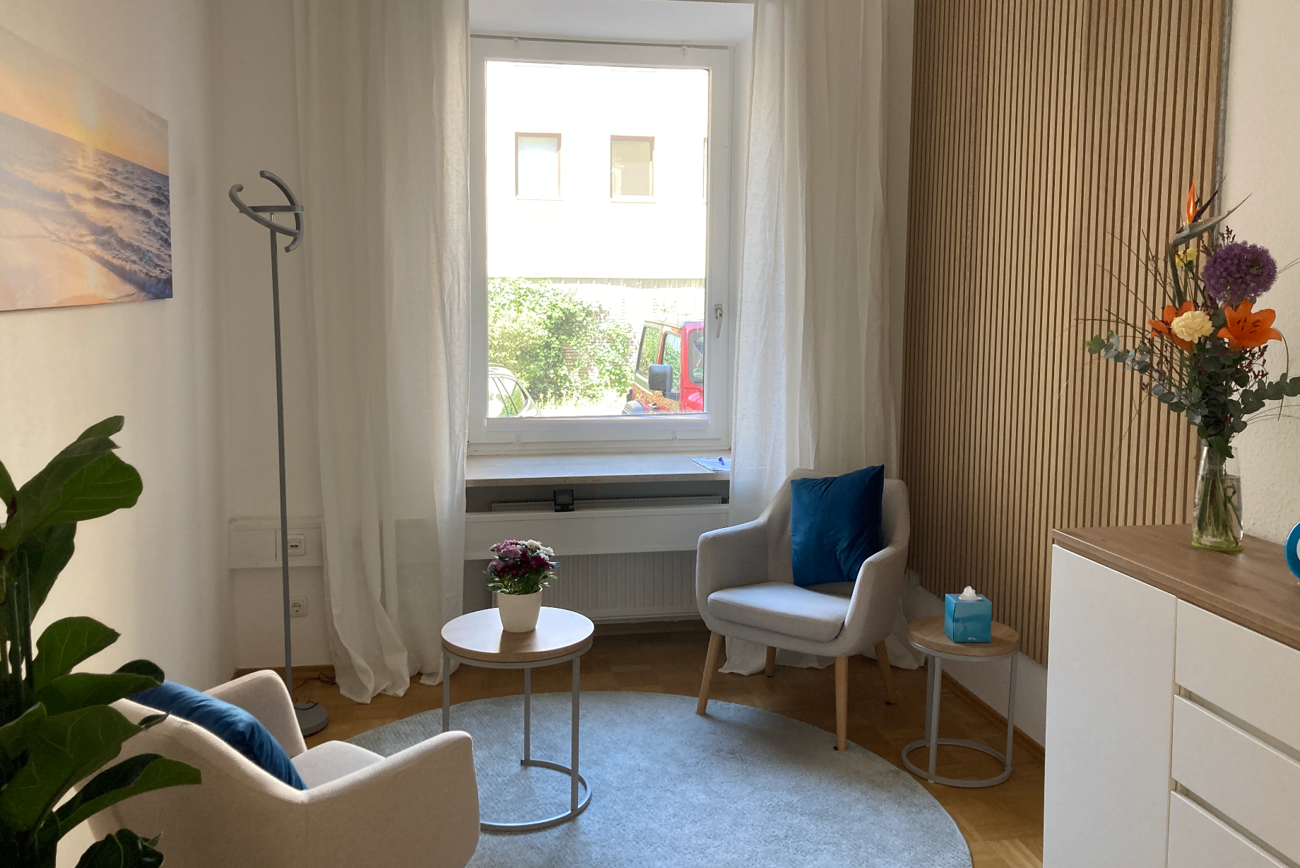 Therapieraum mit Sesseln, Teppich und hellem Tageslicht