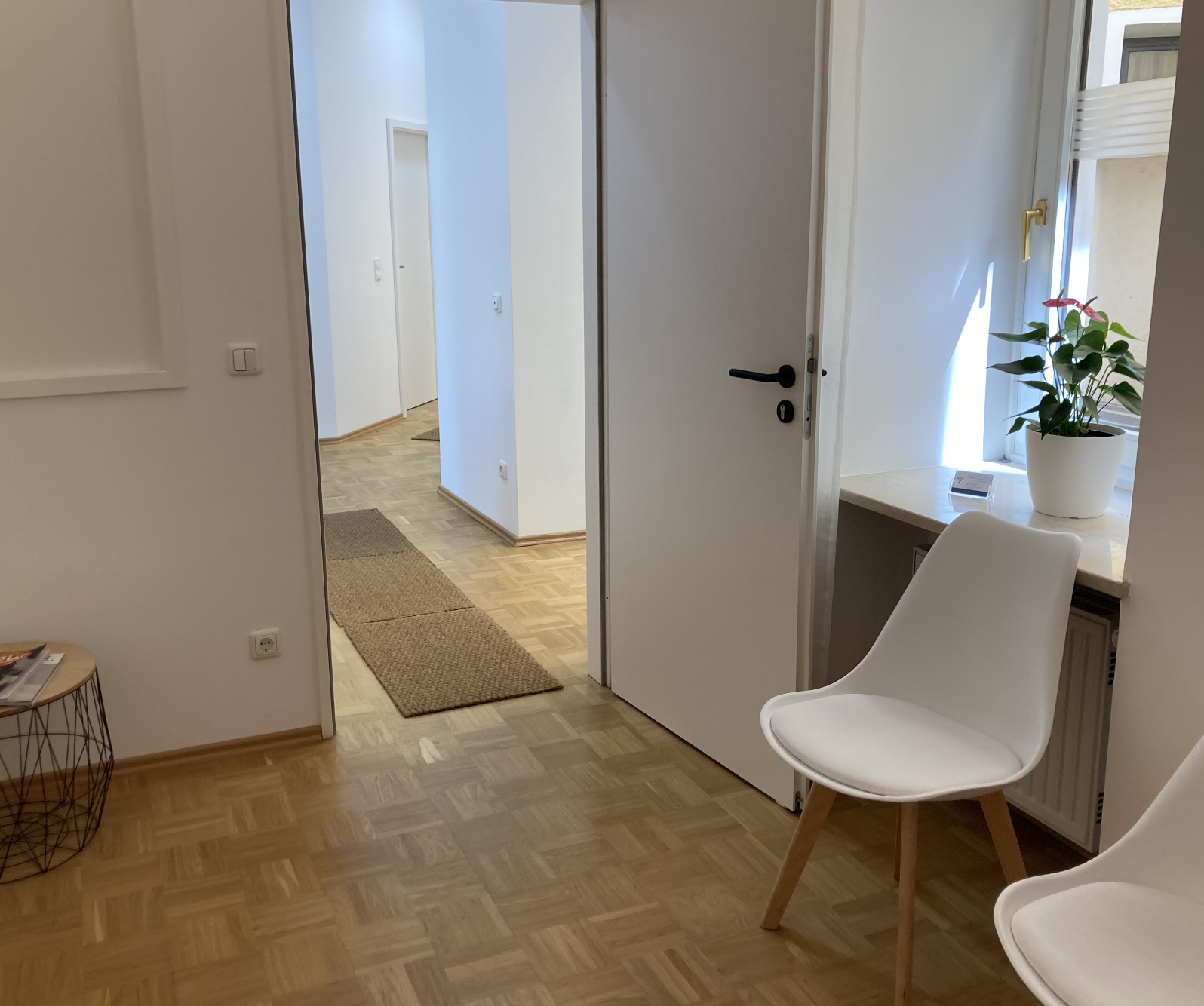 Blick in den Praxisflur mit Wartebereich und Tageslicht