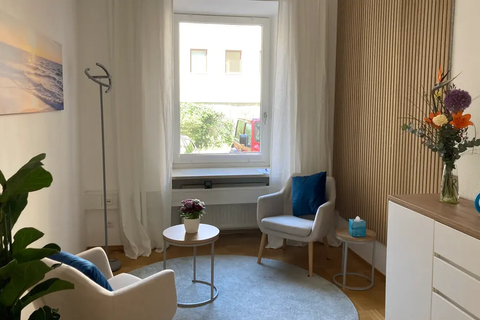 Therapieraum mit Sesseln, Teppich und hellem Tageslicht